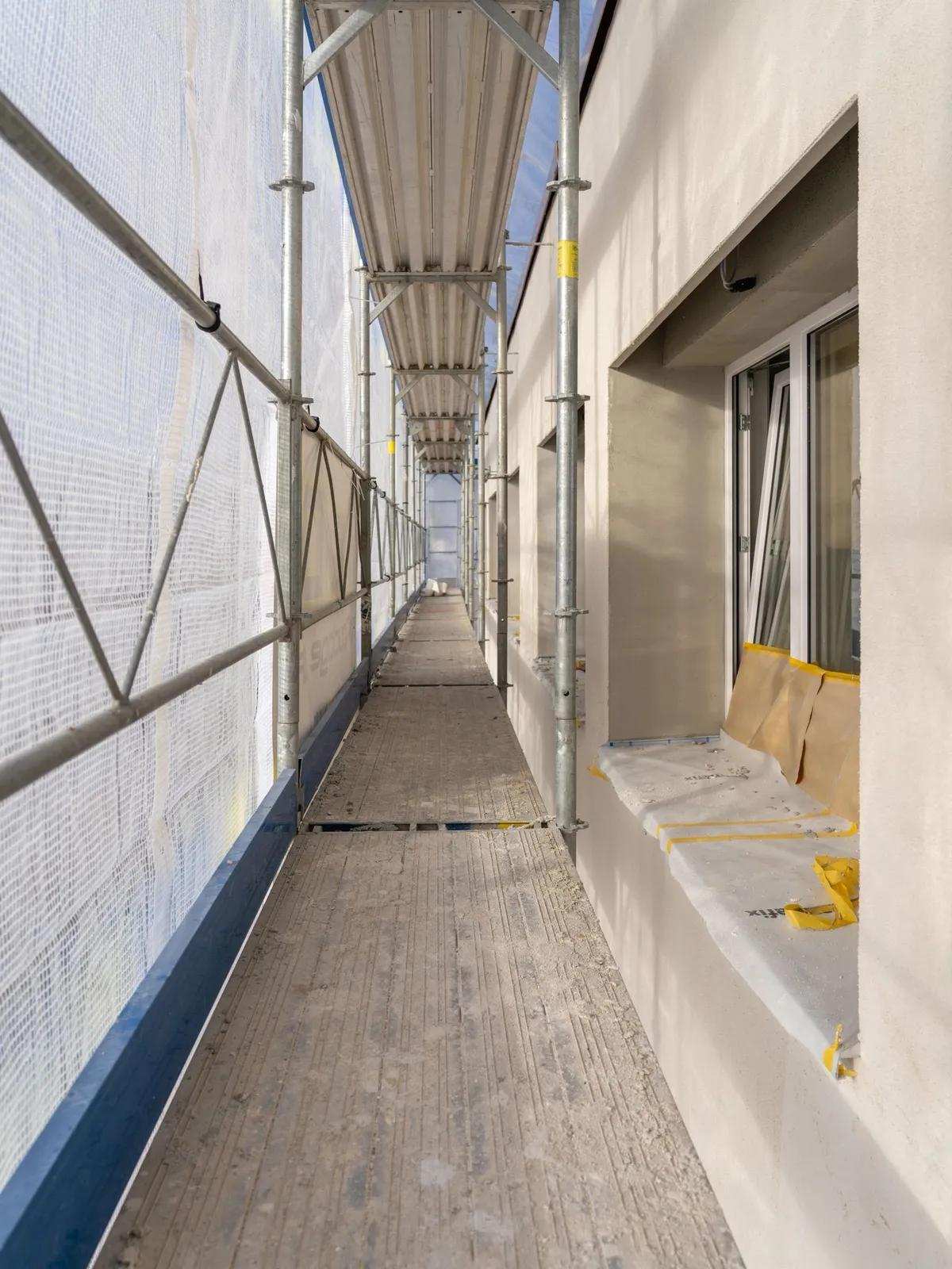 Passerelle d'échafaudage le long d'une façade en travaux