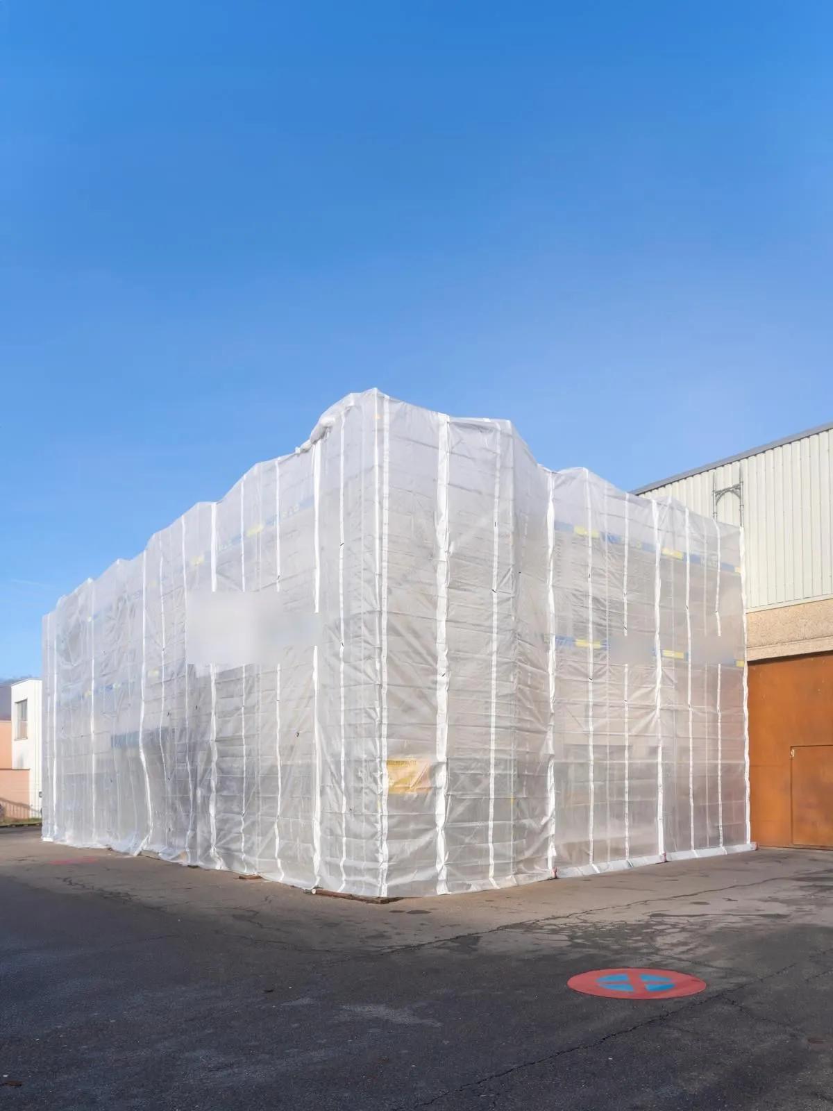 Bâtiment entièrement bâché sous échafaudage pendant les travaux