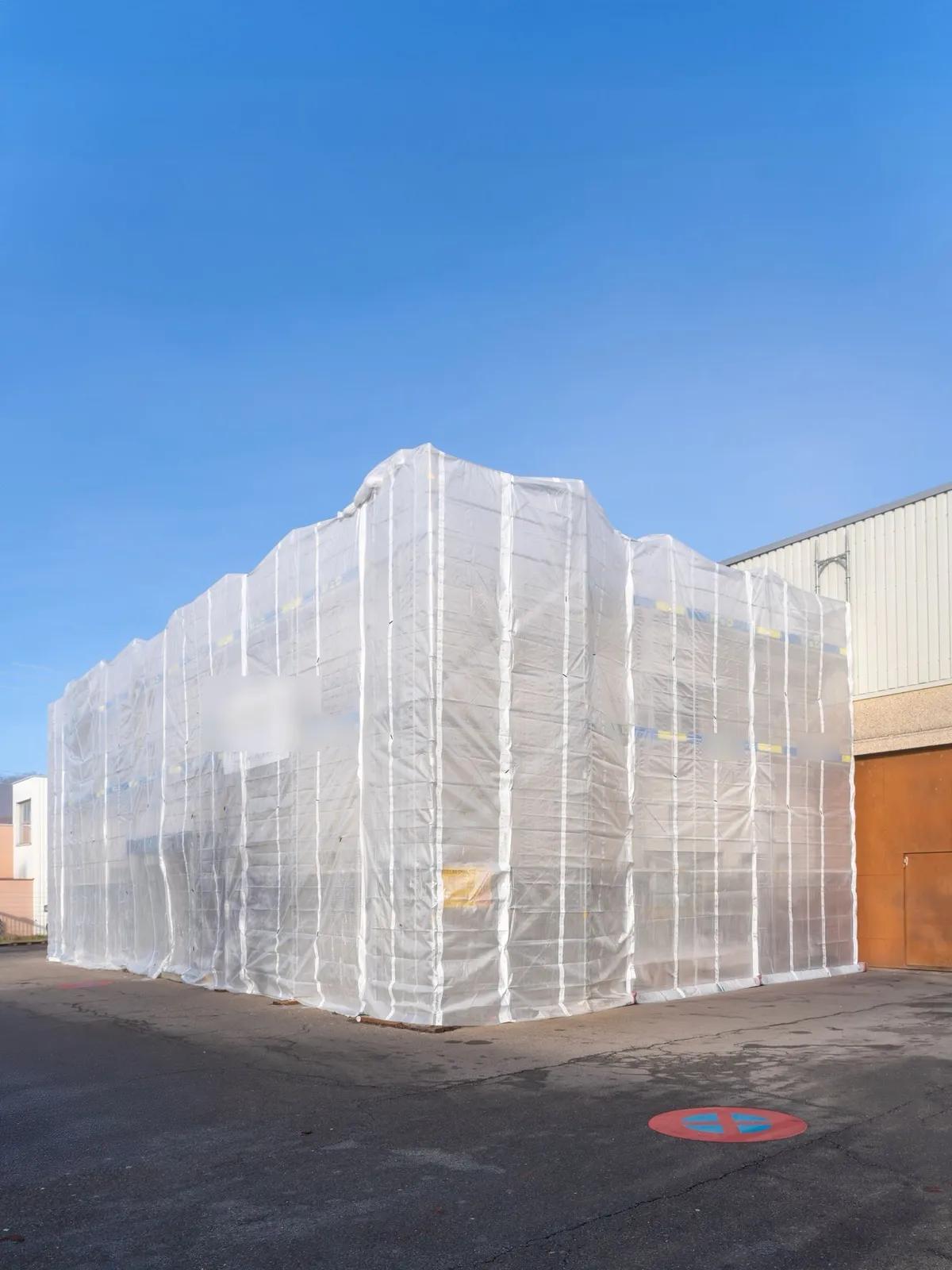 Chantier sous échafaudage bâché, enveloppe du bâtiment protégée pendant les travaux